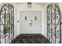 Elegant front entrance with custom wrought iron door and decorative black and marble tile flooring at 15722 Gardenside Ln, Tampa, FL 33624