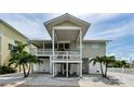 Bright beach home featuring a covered porch, ground-floor entrances, and easy beach access at 19111 Whispering Pines Dr, Indian Shores, FL 33785