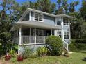 Charming two-story home with a covered porch and well-manicured landscaping at 222 Spring Lake Hwy, Brooksville, FL 34602