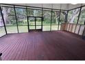 Spacious screened-in patio with a wood floor and a view of the lush backyard at 222 Spring Lake Hwy, Brooksville, FL 34602
