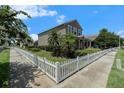 A charming two-story home is showcased from the sidewalk highlighting the yard with a classic white picket fence at 2706 Lantern Hill Ave, Brandon, FL 33511