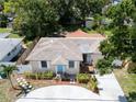 Aerial view of a well-kept single-story home with charming front yard, complemented by a circular driveway at 3115 Bay Ln, Clearwater, FL 33759