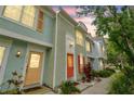 Townhouse exterior featuring vibrant colors and a welcoming entrance with colorful doors, shutters, and landscaping at 3308 W Wyoming Cir, Tampa, FL 33611