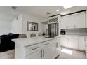 Bright kitchen featuring a center island, stainless steel appliances, white cabinets, and modern finishes at 4727 Town N Country Blvd, Tampa, FL 33615