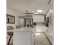 Bright kitchen featuring a center island, stainless steel appliances, white cabinets, and modern finishes at 4727 Town N Country Blvd, Tampa, FL 33615