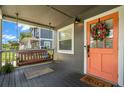 Inviting front porch featuring a porch swing, welcome mat, and a decorative wreath on the front door at 6016 N Dexter Ave, Tampa, FL 33604