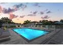 Community pool with lounge chairs and umbrellas at dusk at 6210 64Th N Way, Pinellas Park, FL 33781