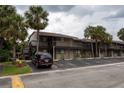 Exterior shot of a condo building with palm trees, parking, and a dark red SUV at 6332 Newtown Cir # 32B2, Tampa, FL 33615