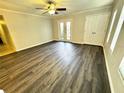 Bright living room featuring updated flooring, a ceiling fan and access to the balcony at 720 Lyndhurst St # 1104, Dunedin, FL 34698