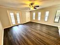 Living room boasts neutral walls, ceiling fan, updated flooring and double doors to a balcony at 720 Lyndhurst St # 1104, Dunedin, FL 34698