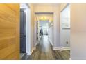 Hallway with light-colored walls, wood-look floors, and white trim leading to other rooms at 7683 Summerland Cv, Lakewood Ranch, FL 34202