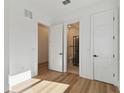 Bedroom with light wood floors, white walls, white doors, and access to a walk-in closet and bathroom at 905 N Willow Ave, Tampa, FL 33606