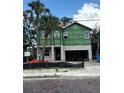 Exterior view of a new home build with tropical landscaping and in the process of being completed at 905 N Willow Ave, Tampa, FL 33606
