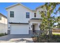 Charming two-story home featuring a pristine white exterior, stylish gray accents, and a well-manicured front yard at 905 N Willow Ave, Tampa, FL 33606