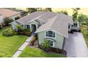 Aerial view of a green home with a well-manicured lawn and a brick walkway to the front door at 916 Bunker View Dr, Apollo Beach, FL 33572