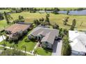 Aerial view of a green home near a lake, showcasing a manicured lawn and beautiful landscaping at 916 Bunker View Dr, Apollo Beach, FL 33572