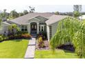 Beautifully landscaped front yard featuring lush green lawn, colorful flower beds, and a charming walkway at 916 Bunker View Dr, Apollo Beach, FL 33572