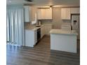 Bright kitchen features white cabinets, stainless appliances, and granite countertops at 1 Windrush Blvd # 84, Indian Rocks Beach, FL 33785