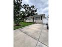 Charming single-story home featuring a well-maintained lawn, a cozy porch, and a concrete driveway at 114 N Arcturas Ave, Clearwater, FL 33765