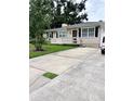Inviting one-story home with a manicured lawn and a spacious driveway, perfect for parking at 114 N Arcturas Ave, Clearwater, FL 33765