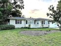 Cozy single-story home with green lawn and landscaping with flower beds in front at 114 N Arcturas Ave, Clearwater, FL 33765