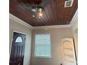 Interior view with dark wood ceiling and trim, a ceiling fan, and a partially visible doorway at 114 N Arcturas Ave, Clearwater, FL 33765
