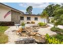 Landscaped front yard with rock water feature, decorative rocks and plants and a stone and siding facade at 1251 Fairway Dr, Dunedin, FL 34698