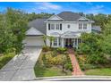 A charming two-story home with white exterior, a well-manicured lawn, brick path, and attached garage at 14617 Galt Lake Dr, Tampa, FL 33626