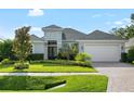 Beautiful home exterior featuring well manicured landscaping, double front doors, and a white two car garage at 15415 Otto Rd, Tampa, FL 33624