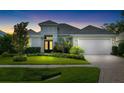 Beautiful home exterior featuring well manicured landscaping, double front doors, and a white two car garage at 15415 Otto Rd, Tampa, FL 33624