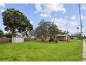 A single-Gathering home set on a sprawling lawn, showcasing classic design and mature trees under a clear sky in a quiet neighborhood at 1560 Connecticut Ne Ave, St Petersburg, FL 33703