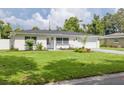 Charming single-story home featuring a manicured front lawn, landscaping, and a two-car garage at 1723 Cypress Ave, Belleair, FL 33756