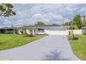Charming single-story home with a long driveway and a basketball hoop out front at 1723 Cypress Ave, Belleair, FL 33756