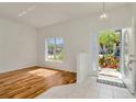 Bright foyer with hardwood flooring, a tiled entryway, and a view of the landscaped yard at 1734 Mapleleaf Blvd, Oldsmar, FL 34677