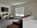 Bright bonus room that features neutral walls and grey carpeting and includes a window with white blinds at 17807 Canopy Pl, Bradenton, FL 34211
