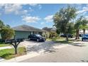 View of the front of a well-maintained house with a driveway and lawn in a residential neighborhood at 1827 Peaceful Palm St, Ruskin, FL 33570