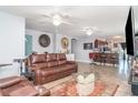 Open-concept living room with tile flooring, comfortable seating, ceiling fans and access to the kitchen at 1827 Peaceful Palm St, Ruskin, FL 33570
