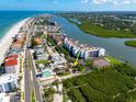 An aerial view of a beachfront property close to the Gulf of Mexico, featuring a tennis court at 19109 2Nd St, Indian Shores, FL 33785