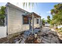 Shows weathered exterior of a cottage-style home, revealing its vintage charm and character at 19109 2Nd St, Indian Shores, FL 33785