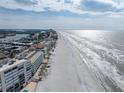 Sweeping aerial view of a beachfront community with a long stretch of sandy beach and ocean at 19440 Gulf Blvd # 301, Indian Rocks Beach, FL 33785