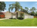 Single-story home with attached two car garage, a well-maintained lawn, and mature landscaping at 2625 Brookville Dr, Valrico, FL 33596