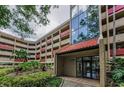 Building entrance showcases a modern glass facade and well-kept garden beds at 3062 Eastland Blvd # 308, Clearwater, FL 33761