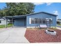 Charming blue home with a cozy porch swing and fire pit in a peaceful community at 3125 Beaver Creek Dr, Wesley Chapel, FL 33543