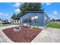 Charming blue home with a cozy porch swing and fire pit on a sunny day at 3125 Beaver Creek Dr, Wesley Chapel, FL 33543