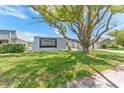 Home exterior highlighting the manicured lawn and a large tree providing shade at 4016 Grayton Dr, New Port Richey, FL 34652