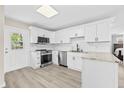 Bright kitchen featuring white cabinetry, stainless steel appliances, and granite countertops at 4718 W Oklahoma Ave, Tampa, FL 33616
