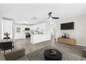 Bright, open-concept living space flows into a modern kitchen featuring white cabinets at 4718 W Oklahoma Ave, Tampa, FL 33616