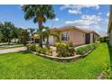 Beautiful home featuring mature landscaping, stone accents and a paver driveway at 5103 Shady Stone Pl, Wimauma, FL 33598