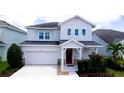 Charming two-story home features a red front door, attached garage, and well-manicured landscaping at 5546 Spanish Moss Cv, Bradenton, FL 34203