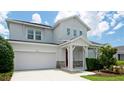 Charming two-story home features a red front door, attached garage, and well-manicured landscaping at 5546 Spanish Moss Cv, Bradenton, FL 34203